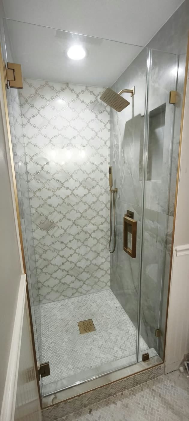 Walk-in shower with white arabesque mosaic tile, gold fixtures and a frameless glass door — ProRock Remodeling, Bay Area