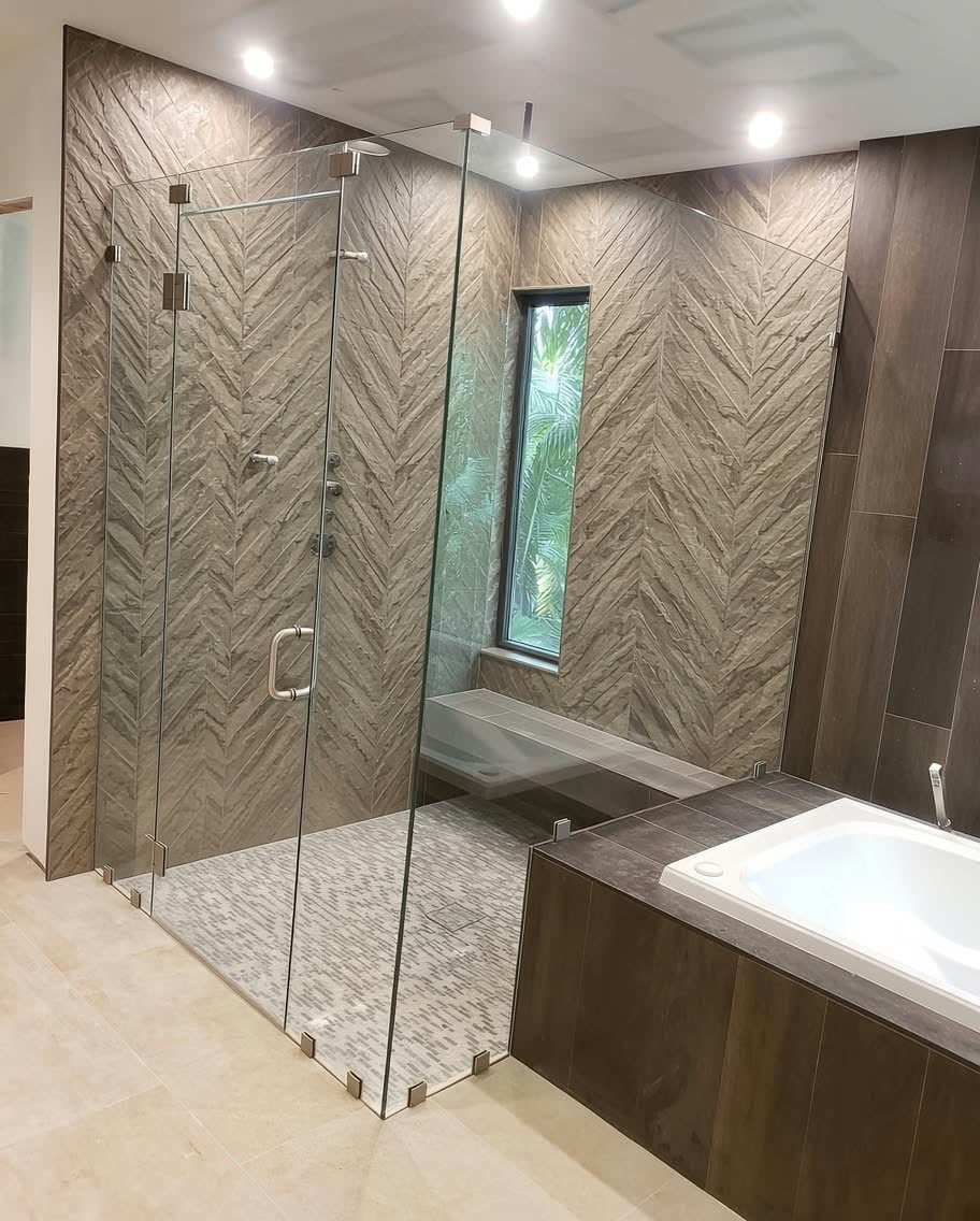 Walk-in shower with chevron stone tile next to a wood-clad soaking tub — ProRock Remodeling, Bay Area