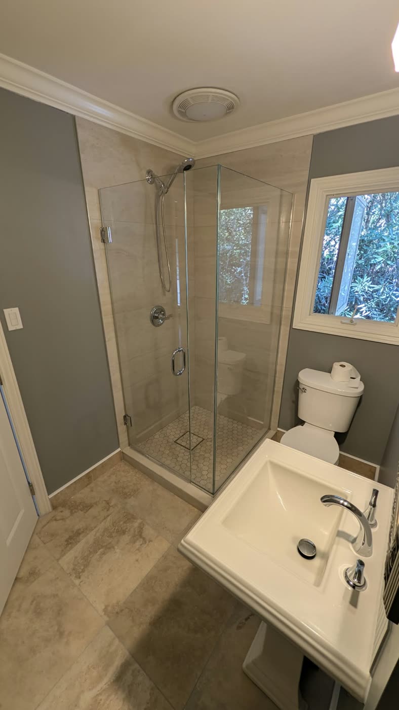 Compact corner glass shower in a small bathroom with a pedestal sink — ProRock Remodeling, Bay Area