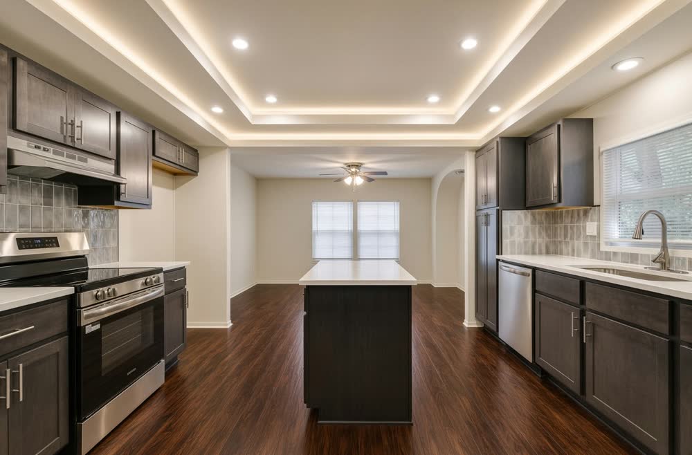 Kitchen with a lit tray ceiling, dark shaker cabinets, stainless appliances and a center island — ProRock Remodeling, Bay Area