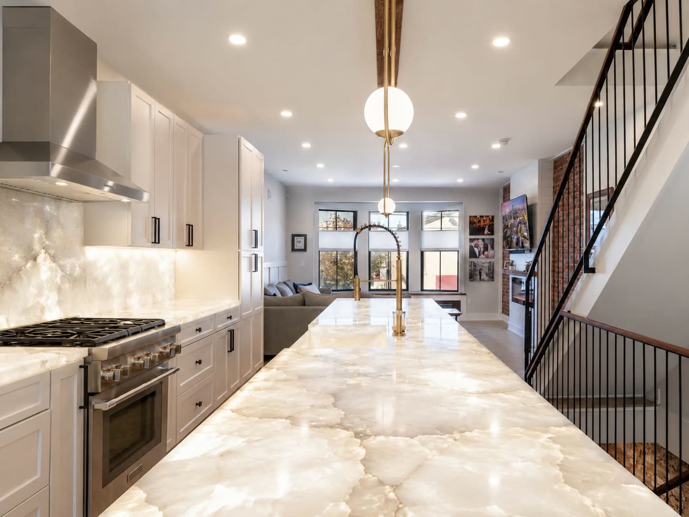Open kitchen with a backlit onyx island, a professional range and a staircase alongside — ProRock Remodeling, Bay Area