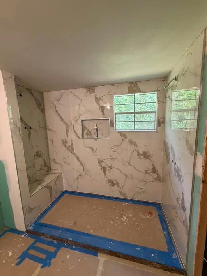 Shower remodel in progress: marble-look wall tile, a bench and a niche over a waterproofed shower pan — ProRock Remodeling, Bay Area