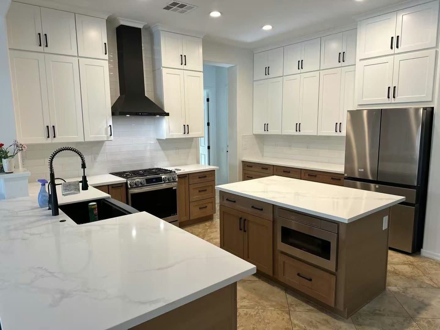 White shaker kitchen with a quartz-topped wood island, black range hood and stainless appliances — ProRock Remodeling, Bay Area
